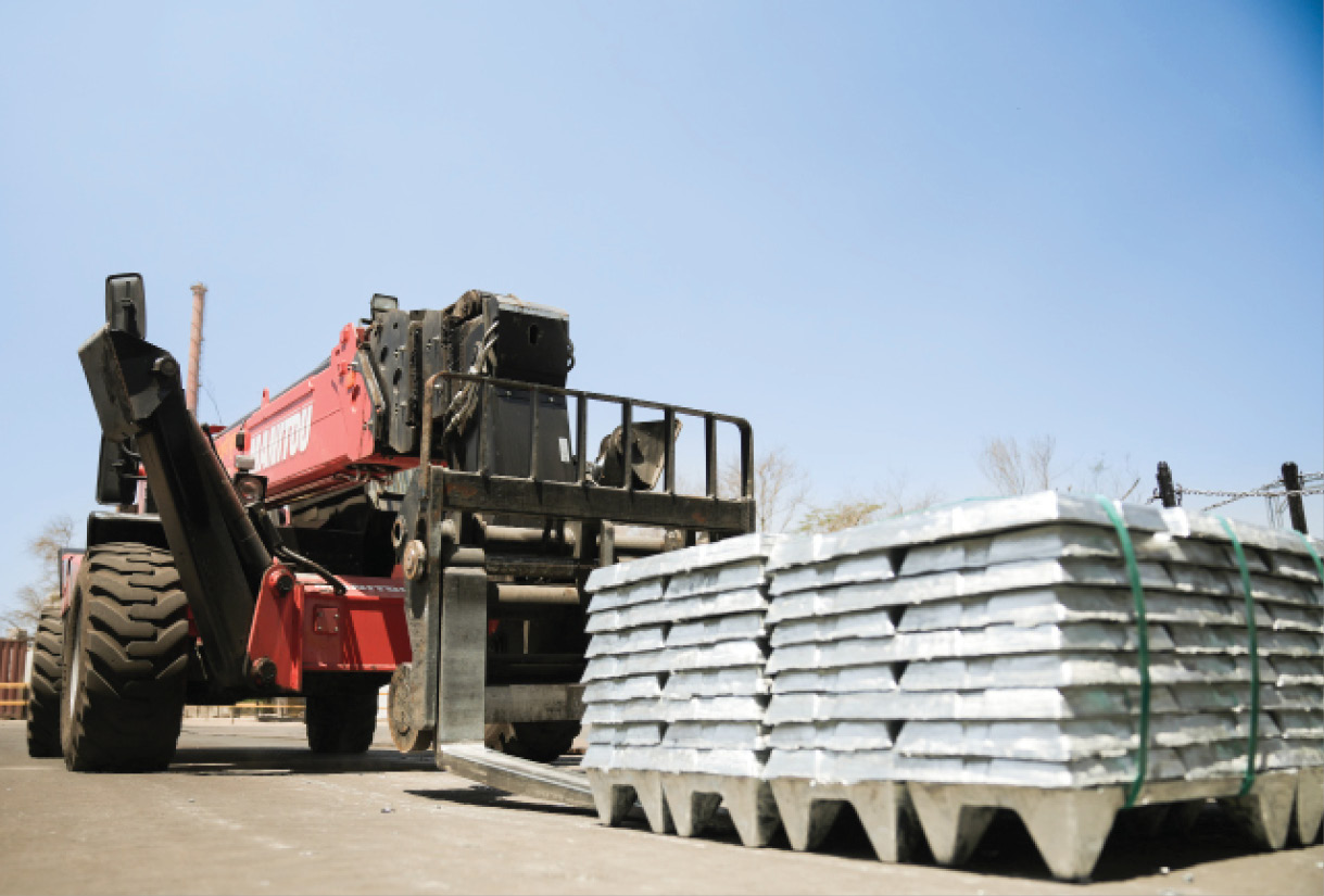 Stacked metal ingots with a handler