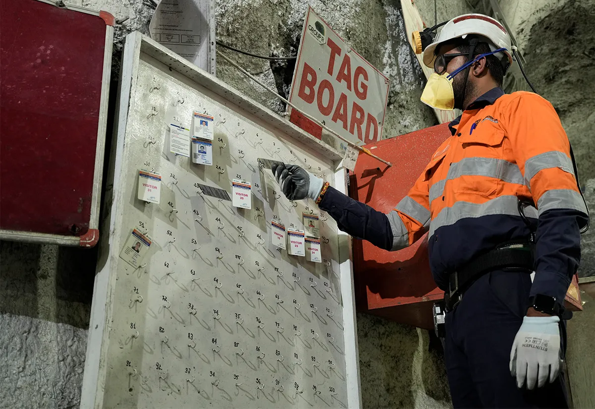Mine worker in protective gear at an underground tag board